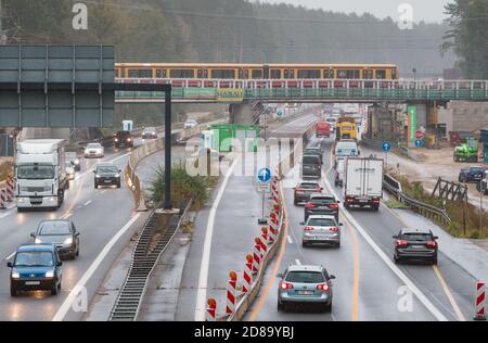 08. Oktober 2020, Brandenburg, Birkenwerder: Auf dem Abschnitt zwischen Birkenwerder und Borgsdorf an der Brücke über die Autobahn A10 verkehrt eine S-Bahn. Aufgrund von Bauarbeiten passieren Autos und Lastwagen auf vier verengten Fahrspuren die Kreuzung Birkenwerder. Zum ersten Mal ist aufgrund der Bauarbeiten eine vollständige Schließung der Berliner Nordringstraße zwischen den Kreuzungen Pankow und Oranienburg unter der Woche geplant. Vom 8. November bis zum 11. November 2020 werden die S-Bahnbrücken zwischen Birkenwerder und Borgsdorf erneuert, was auch zu Unterbrechungen im S-Bahnverkehr führen wird. P Stockfoto