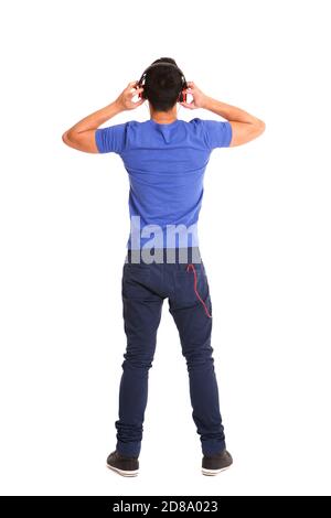 Ganzkörperporträt von hinten von einem Mann mit Kopfhörern Zum Abhören von Musik auf weißem Hintergrund Stockfoto