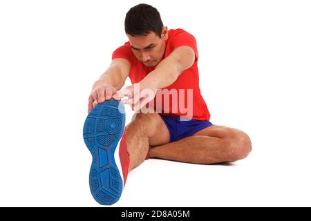 Portrait des Mannes mittleren Alters, der Stretching-Übung auf weißem Hintergrund macht, sitzt und seine Zehen härtet. Stockfoto