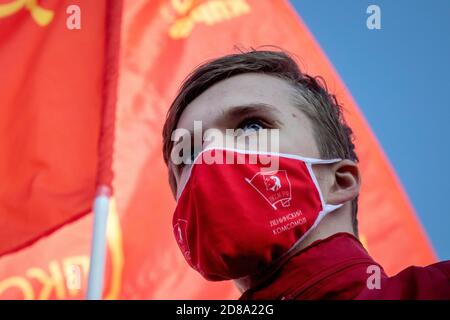 Moskau, Russland. 28. Oktober 2020 EIN Anhänger der kommunistischen Partei, trägt eine rote Gesichtsmaske mit sowjetischem Komsomolabzeichen, nimmt an der Kundgebung der Kommunistischen Partei auf dem Roten Platz Teil, um den 102. Jahrestag des Komsomol zu begehen, Oder die All-Union Leninist Young Communist League, die kommunistische Jugendorganisation der Sowjetzeit, in Moskau während der neuartigen Coronavirus COVID-19 Krankheit in Russland Stockfoto