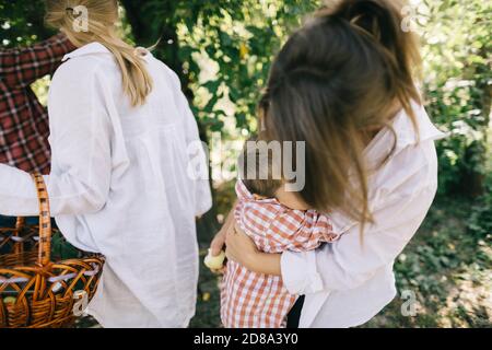 Der Sohn umarmte seine Mutter, die sich stark in ihren Haaren versteckte Im Garten der Familie Stockfoto