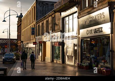 Coatbridge, North Lanarkshire, Schottland, Großbritannien. 28. Oktober 2020. Blick auf das Stadtzentrum von Coatbridge, einer Stadt in North Lanarkshire, die nach dem neuen Coronavirus-System der schottischen GovernmentÕs Level 4 gesperrt werden könnte, um die Ausbreitung des Virus zu kontrollieren. Blick auf Geschäfte und Geschäfte entlang der Main Street in der Abenddämmerung. Iain Masterton/Alamy Live News Stockfoto