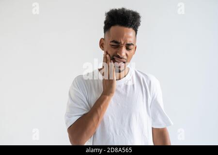 Nahaufnahme Porträt des jungen Mannes in roten Hoodie mit Zahnschmerzen Krone Problem über zu weinen Schmerzen berühren außerhalb Mund mit der Hand, isoliert weißen Rücken Stockfoto