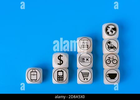 Urlaubskonzept mit Symbolen auf Holzwürfeln, blauer Hintergrund. Das Konzept des Reisens um die Welt. Stockfoto