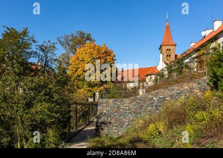 Pruhonice, Tschechische Republik - Oktober 25 2020: Blick auf die römisch-gotische Kirche der Geburt der Jungfrau Maria, die in einem Park mit bunten Bäumen steht. Stockfoto