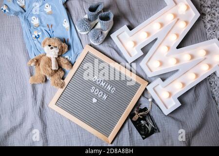 In Kürze verfügbar. Baby Ansagetafel auf grauem Hintergrund. Demnächst erhältlich. Stockfoto