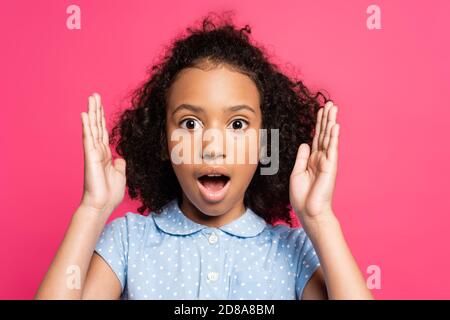 Schockiert niedlich lockig afroamerikanischen Kind isoliert auf rosa Stockfoto