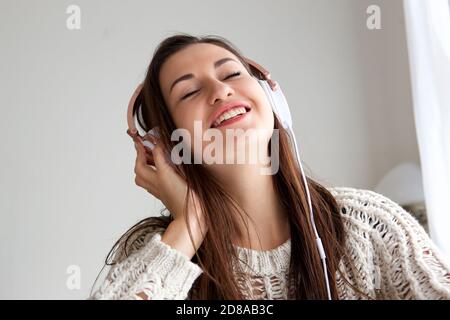 Nahaufnahme Porträt der jungen Frau, die Musik mit hören Augen geschlossen Stockfoto