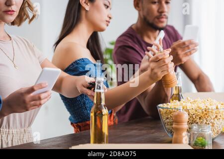 Selektiver Fokus von multiethnischen Freunden chatten auf Smartphones während der Party Stockfoto