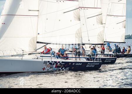 Russland, St.Petersburg, 06. Juli 2020: Die Segelboote Regatta am Neva Fluss an sonnigen Tag, Start des Rennens, Spaß, Leidenschaft, Sonne Flecken von Licht auf dem Wasser Stockfoto