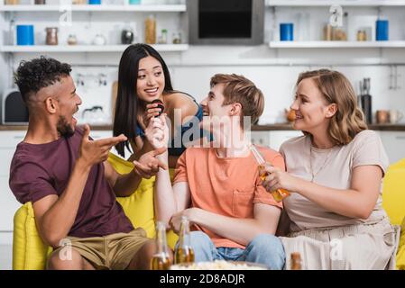 afroamerikanischer Mann zeigt mit Händen, während multiethnische Freunde singen Karaoke Stockfoto