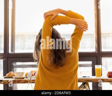 Rückansicht der gesichtslosen jungen Frau mit steifen Muskeln, angespannt und Gelenkschmerzen Stockfoto