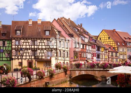 Malerischer Blick auf die Colmar Straße. Fachwerkhäuser, bunte Architektur, Kanal und blauer Himmel. Reiseziel. Elsass, Frankreich Stockfoto