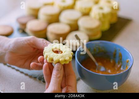 Oma macht traditionelle deutsche spitzbuben weihnachtskekse linzer Keks Cookies gefüllt Mit Marmelade Stockfoto