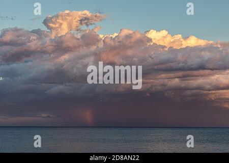 Dramatische Wolken in einem Sonnenuntergang Licht und Regenbogen über dem mittelmeer, Costa Brava in Spanien Stockfoto