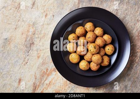 Mediterrane frittierte Falafels, aus Kichererbsen mit Gewürzen mit Koriander und Kreuzkümmel auf schwarzem Teller, Draufsicht, Nahaufnahme Stockfoto