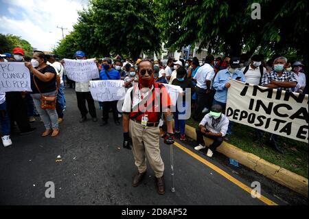 San Salvador, El Salvador. Oktober 2020. Demonstranten halten Zeichen hoch und singen bei einem Protest, der die Zahlung des FODES-Fonds fordert.Zahlungen für über 240 Millionen US-Dollar sind noch nicht von der Regierung geleistet worden und Gemeinden riskieren den Verlust von Strom und anderen kommunalen Dienstleistungen. Quelle: Camilo Freedman/ZUMA Wire/Alamy Live News Stockfoto