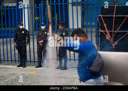 San Salvador, El Salvador. Oktober 2020. Polizei guardi das Finanzministerium beobachtet als Demonstrator feuert ein selbstgebautes Feuerwerk während eines Protestes, der die Zahlung des FODES-Fonds fordert.Zahlungen für über 240 Millionen US-Dollar sind noch nicht von der Regierung geleistet worden und Gemeinden riskieren, Strom und andere kommunale Dienstleistungen zu verlieren. Quelle: Camilo Freedman/ZUMA Wire/Alamy Live News Stockfoto