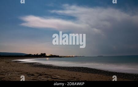 Sand- und Kieselstrand des Mittelmeers, nachts bei ruhigem Wetter mit langer Belichtung beschossen. Stockfoto