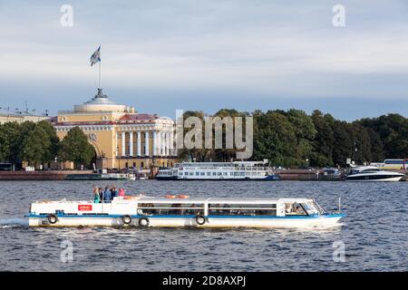 ST. PETERSBURG, RUSSLAND-CIRCA SEP, 2015: Kreuzfahrtschiff liegt auf der Neva gegen das Admiralität-Gebäude. Navy Flagge Wellen auf Turm. Das Admira Stockfoto