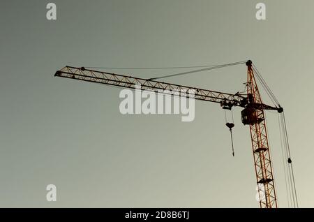 Industrielle Baukräne und Gebäude Silhouetten über Sonne bei Sonnenaufgang Stockfoto