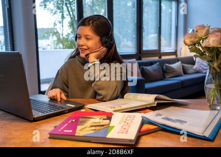 Homeschooling, Mädchen, 11 Jahre alt, zu Hause lernen, zu Hause lernen, Unterricht zu Hause, Fernunterricht, Chat mit Lehrern und Mitschülern über Laptop, Stockfoto