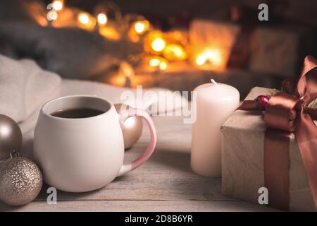Festive background in warm coffee tones with a Cup of coffee and a gift in a cozy Christmas atmosphere. Stockfoto