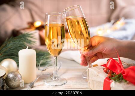 Hand holding a glass of champagne on a Christmas background. Stockfoto