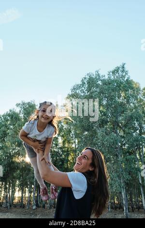 Eine Mutter spielt mit ihrer Tochter, indem sie sie hochhebt Stockfoto