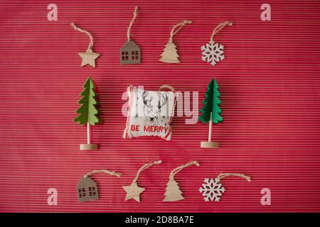 weihnachtsschmuck und Bäume liegen flach auf rotem Hintergrund Stockfoto