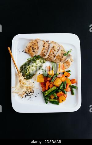 Gegrillte Ente mit Herbstgemüse auf schwarzem Hintergrund Stockfoto