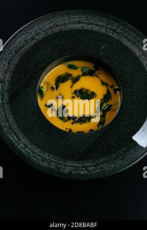 Herbstsuppe mit Kürbiscreme auf schwarzem Hintergrund Stockfoto