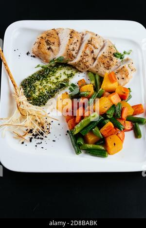 Gegrillte Ente mit Herbstgemüse auf schwarzem Hintergrund Stockfoto