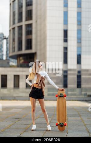 Schöne Blondine mit einem Skate in ihren Händen. Stockfoto