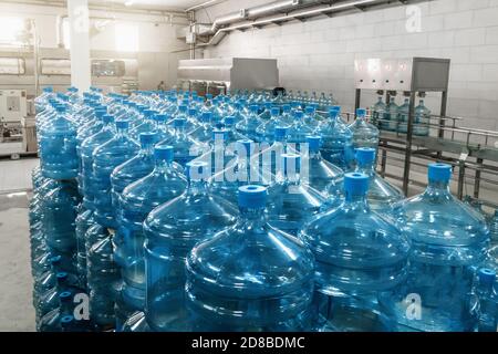 Gallonen oder Plastikflaschen von gereinigtem Trinkwasser in der Wasserproduktionsfabrik. Stockfoto