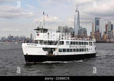 Statue Cruises' Schiff 'miss New York', das Touristen nach Libery Island und Ellis Island bringt, vor der Skyline von Manhattan Stockfoto