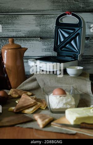 Sandwiches, Teigzutaten und Küchenutensilien auf einem Holztisch zubereiten, Stockfoto