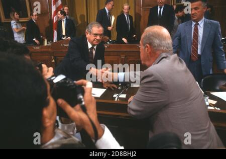 US-Außenminister George P. Shultz, Mitte, schüttelt am Ende seiner Aussage vor dem gemeinsamen Iran-Contra-Komitee des US-Repräsentantenhauses und des US-Senats auf dem Kapitol in Washington, DC, am 24. Juli 1987 die Hände mit dem US-Abgeordneten Dante Fascell (Demokrat von Florida), links. Auf der rechten Seite sieht man den US-Vertreter Paul Sarbanes (Demokrat von Maryland)Kredit: Ron Sachs/CNP weltweit Stockfoto