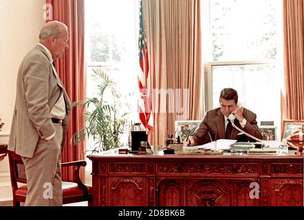 Auf diesem Foto, das vom Weißen Haus veröffentlicht wurde, wird US-Präsident Ronald Reagan gezeigt, als er am 12. August 1982 vom Oval Office des Weißen Hauses in Washington, DC mit Premierminister Menachem Begin telefoniert. Der Präsident äußerte seine Unmut über die israelische Bombardierung Beiruts, die die Verhandlungen des US-Gesandten Phillip Habib behindert. Von links schaut US-Außenminister George P. Shultz. Pflichtkredit: Mary Anne Fackelman/White House via CNP - weltweite Nutzung Stockfoto