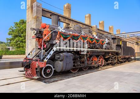 Eine Dampflokomotive mit bunten festlichen Dekorationen auf der Plattform In einem Bahnhof.Festlich oder weihnachten Hintergrund Stockfoto