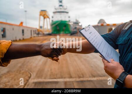 Marine Auftragnehmer Geschäftsmann Handshake mit Arbeiter auf dem Schiff Stockfoto