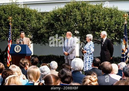 US-Präsident Ronald Reagan macht Bemerkungen, bevor George P. Shultz am 16. Juli 1982 im Rosengarten des Weißen Hauses in Washington, DC, als 60. Außenminister der Nation vereidigt wird. Von links nach rechts: Präsident Reagan, designierter Staatssekretär Shultz, Frau George Shultz (Helena) und US-Generalstaatsanwalt William French Smith.Quelle: Howard L. Sachs / CNP / MediaPunch Stockfoto