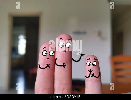 Zwei Finger sind als drei Personen dekoriert. Das Kind hat ein geringes Selbstvertrauen. Stockfoto