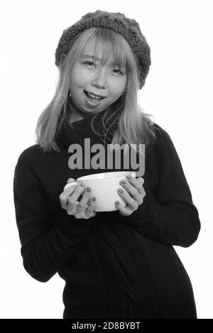 Junge asiatische Frau glücklich und lächelnd Kaffeetasse Stockfoto