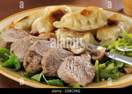 Ein Teller mit Roastbeef und Sticker mit grünen Bohnen Stockfoto