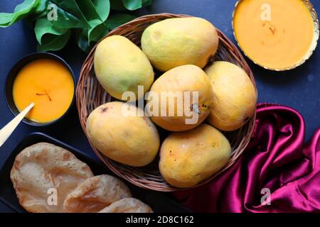 Indisches Essen - Aamras ist ein süßes Gericht, das aus dem Fruchtfleisch der Alphonso-Mangofrucht hergestellt wird. Serviert mit heißen puri/Poori. Süßes Mango-Püree. Stockfoto