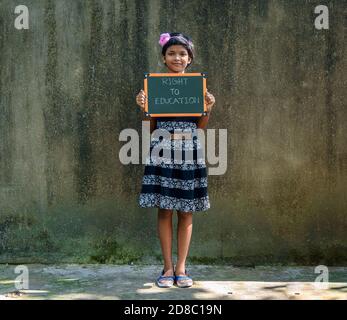 Durgapur, Indien - Oktober 15,2020. Ein kleines Mädchen steht und hält ein Green Board geschrieben "Recht auf Bildung", EIN Konzept Bild. Stockfoto