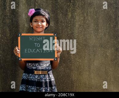 Durgapur, Indien - Oktober 15,2020. Ein kleines Mädchen steht und hält ein Green Board geschrieben "Recht auf Bildung", EIN Konzept Bild. Stockfoto