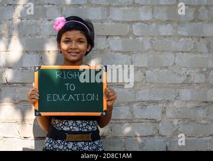 Durgapur, Indien - Oktober 15,2020. Ein kleines Mädchen steht und hält ein Green Board geschrieben "Recht auf Bildung", EIN Konzept Bild. Stockfoto