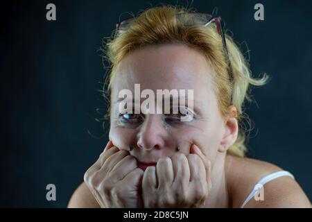 Porträt einer weißen Frau mittleren Alters, die vor Schmerz und Verzweiflung weint, mit Make-up, das ihr ins Gesicht läuft Stockfoto